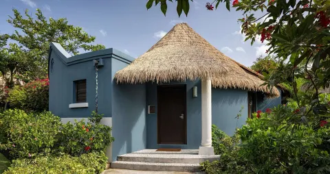 Thatched rondoval suite entrance surrounded by gardens at Sandals Grenada.