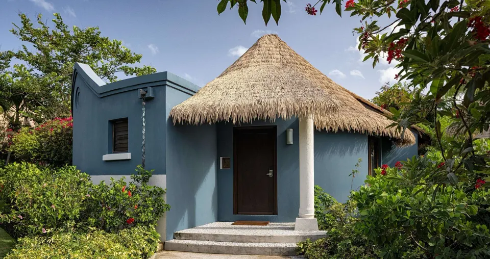 Thatched rondoval suite entrance surrounded by gardens at Sandals Grenada.