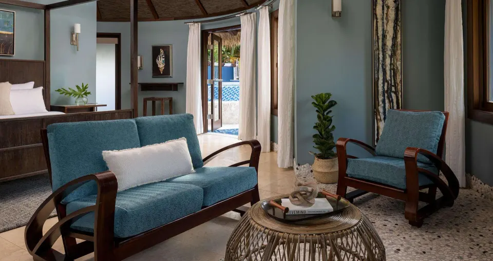 Sitting area with blue sofa in a garden view suite at Sandals Grenada.