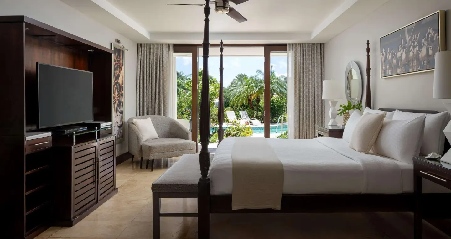 South Seas Walkout Junior Suite bedroom with four-poster bed at Sandals Grenada.