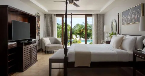 South Seas Walkout Junior Suite bedroom with four-poster bed at Sandals Grenada.