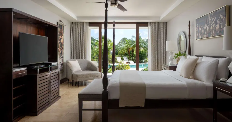 South Seas Walkout Junior Suite bedroom with four-poster bed at Sandals Grenada.