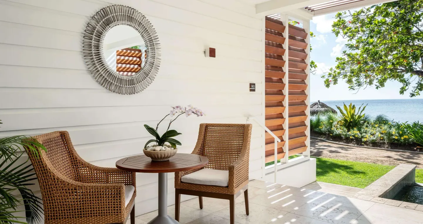 Covered patio with wicker chairs and sea view at Sandals Halcyon.
