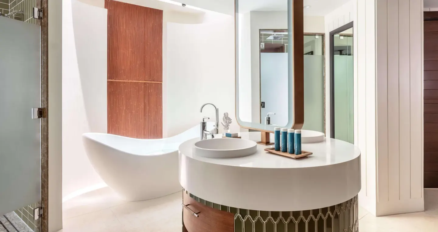 Bright bathroom with freestanding tub and round vanity at Sandals Halcyon.