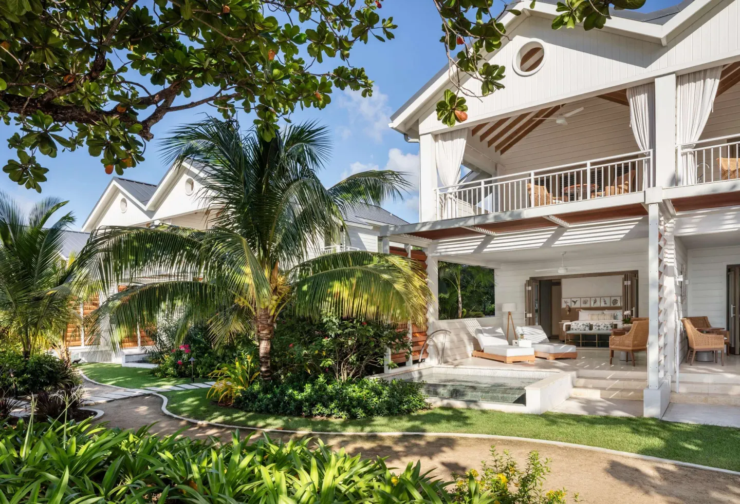 White guest suite buildings with patios and plunge pools at Sandals Halcyon.