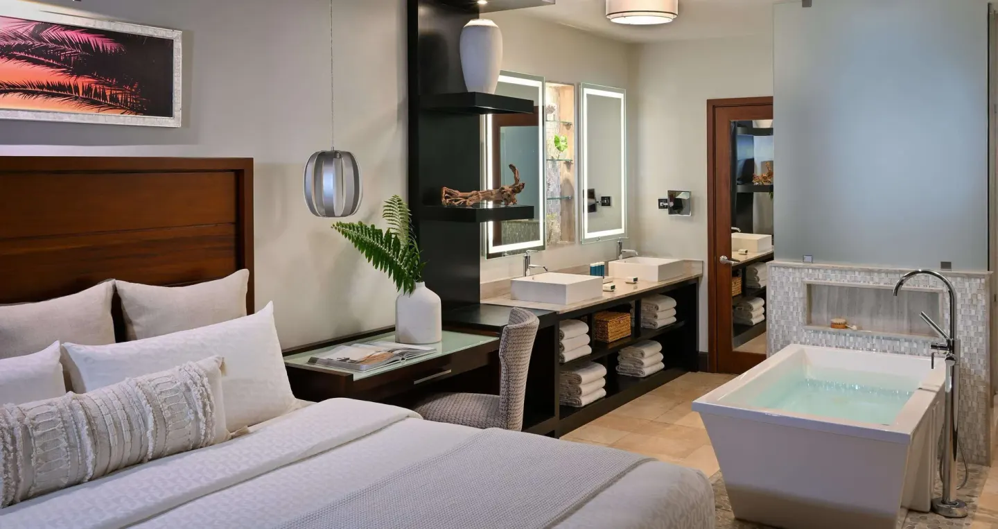 King bed suite with double vanity and soaking tub at Sandals Halcyon.