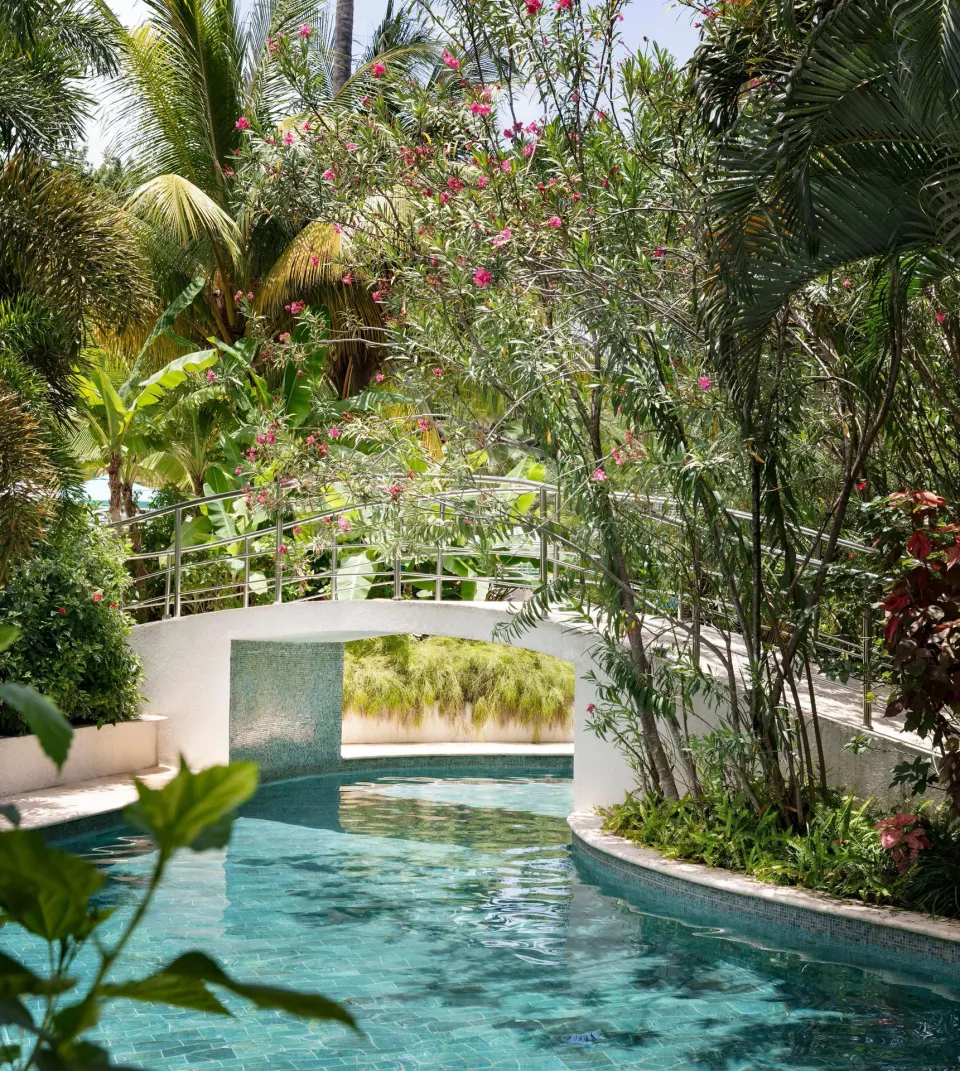 Lagoon-style pool winding through tropical gardens at Sandals Halcyon.