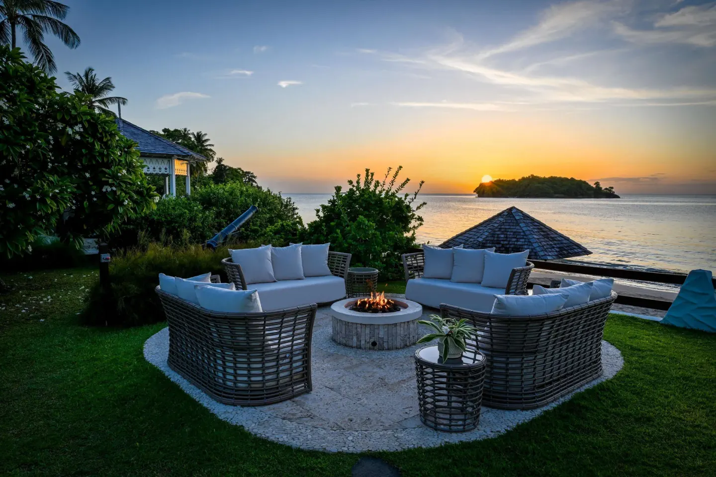 Oceanfront fire pit seating at sunset at Sandals Halcyon.