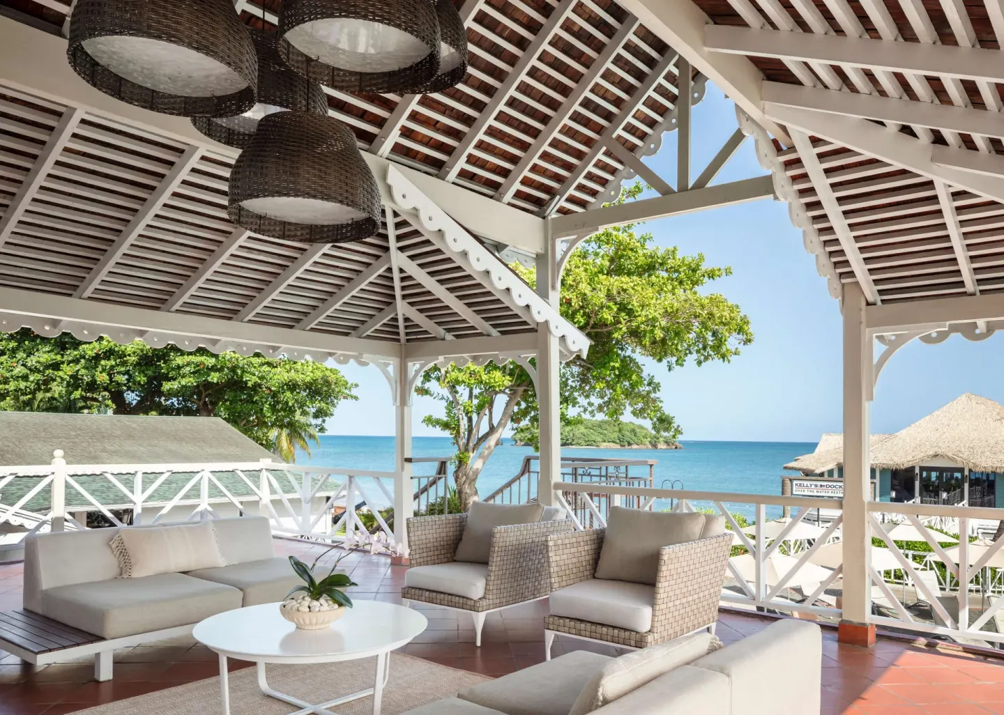 Open-air lounge with ocean view and Kelly's Dockside beyond at Sandals Halcyon.