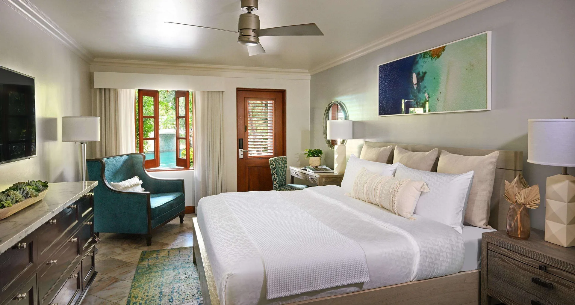 Club Room king bed with teal chair and swim-up view at Sandals Halcyon.