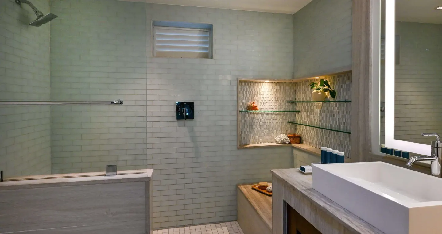 Club Room bathroom with walk-in shower, vanity, and glass shelves at Sandals Halcyon.