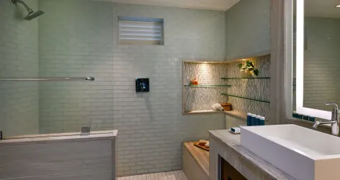 Club Room bathroom with walk-in shower, vanity, and glass shelves at Sandals Halcyon.