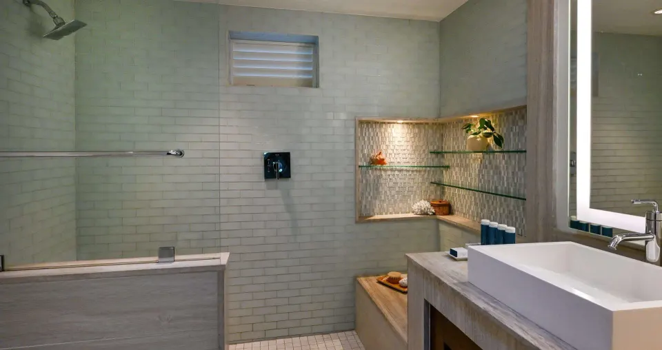 Club Room bathroom with walk-in shower, vanity, and glass shelves at Sandals Halcyon.