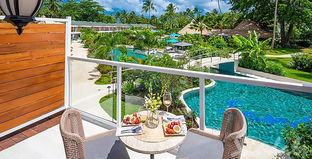Poolside balcony dining setup overlooking the lagoon pool at Sandals Halcyon.