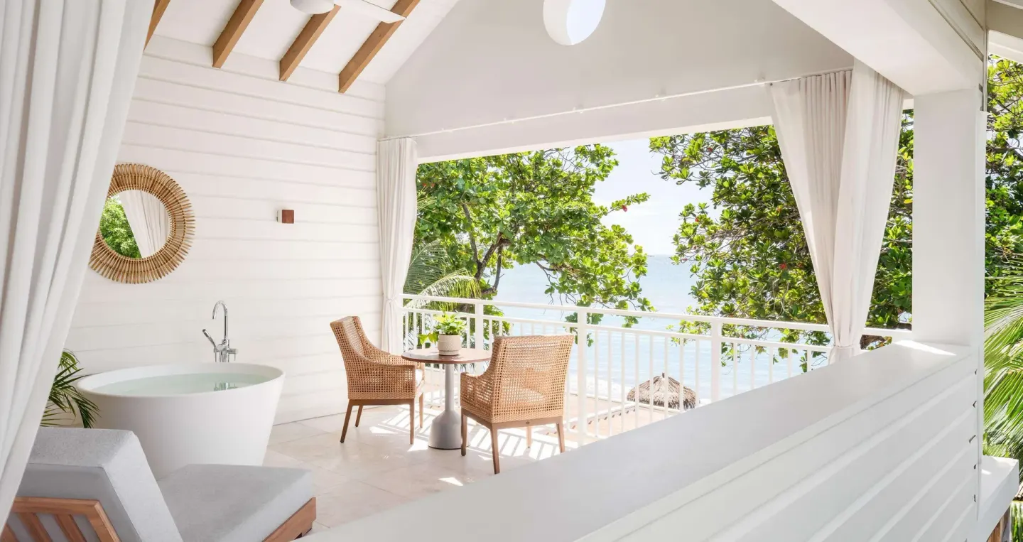 Balcony dining table and soaking tub in a Shore House Butler Suite at Sandals Halcyon.
