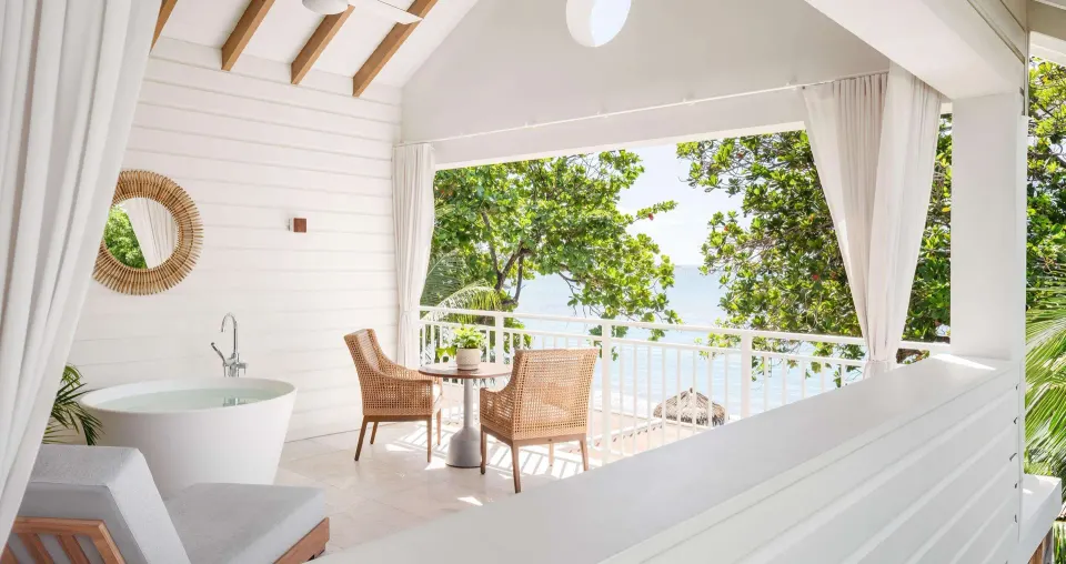 Balcony dining table and soaking tub in a Shore House Butler Suite at Sandals Halcyon.