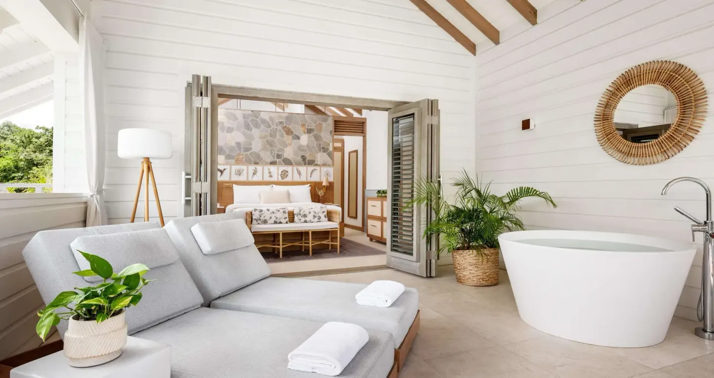 Balcony soaking tub and chaise lounge in a Shore House Butler Suite at Sandals Halcyon.