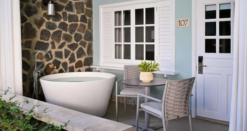 Luxury Room walkout patio with soaking tub and bistro seating at Sandals Halcyon.