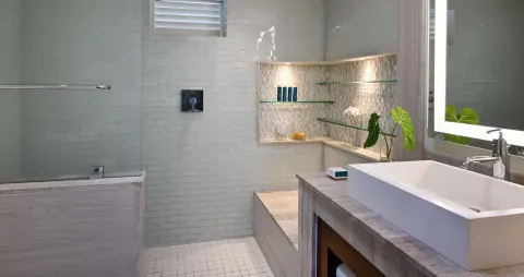 Bathroom with vessel sink, glass shower, and tiled niche at Sandals Halcyon.