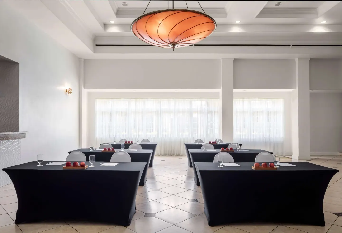 Meeting room with classroom tables and a large pendant light at Sandals Halcyon.