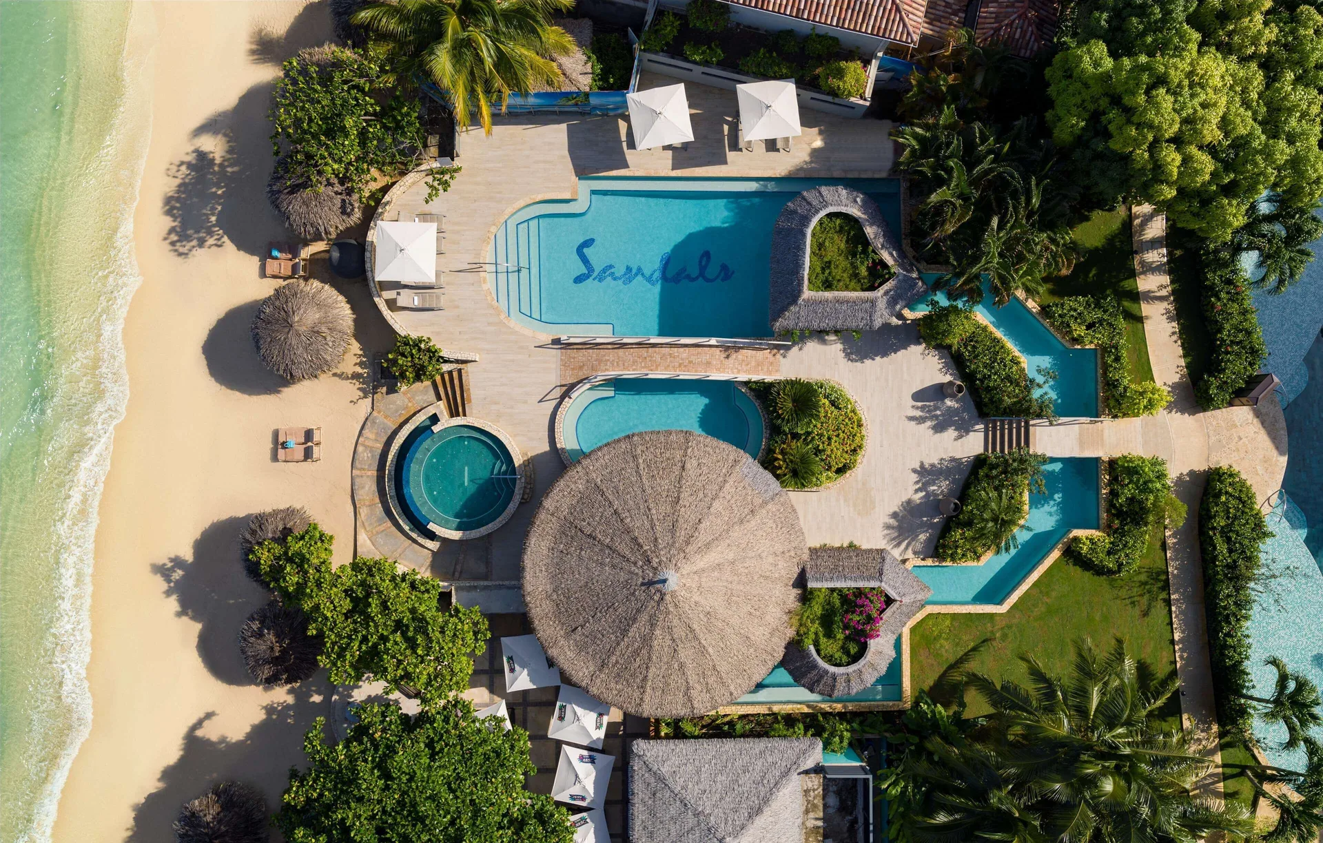 Aerial view of beachfront pools and pathways at Sandals Montego Bay.