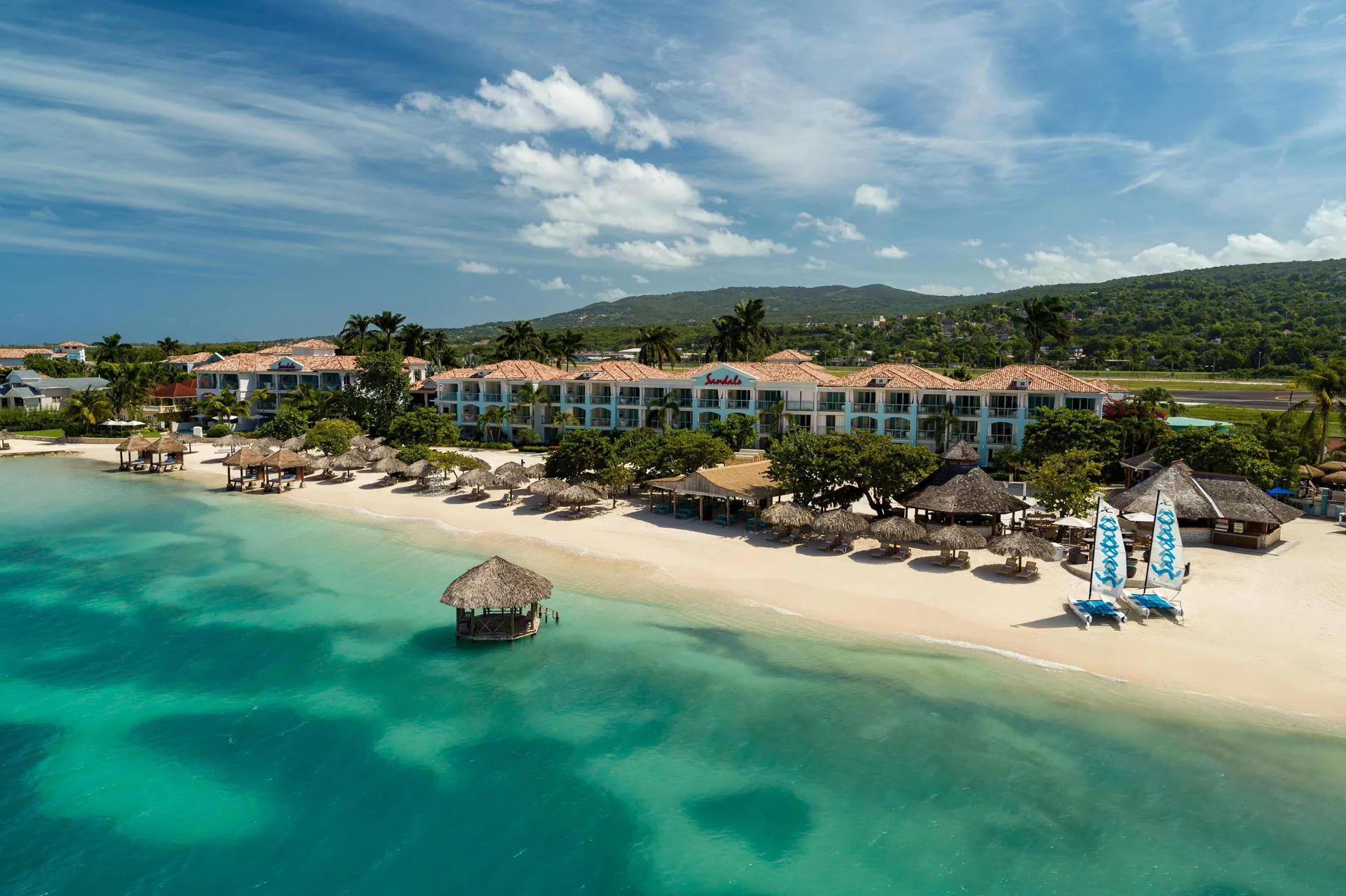 Sandals Montego Bay adults-only all-inclusive resort on a private beach in Jamaica with overwater bungalows and Caribbean Sea views.