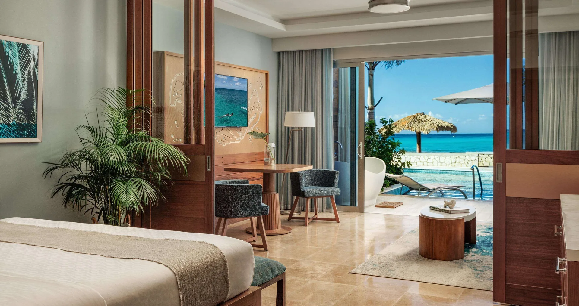 Beachfront suite with king bed, sitting area, patio pool and ocean view at Sandals Montego Bay.