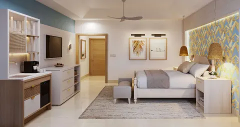 Contemporary king bedroom with kitchenette and blue accent wall at Sandals Montego Bay.