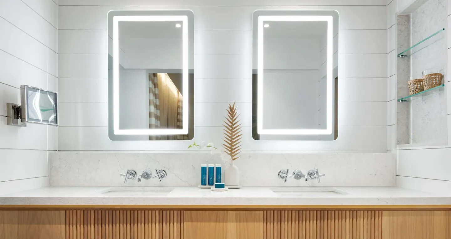 Double vanity with illuminated mirrors in a bathroom at Sandals Montego Bay.