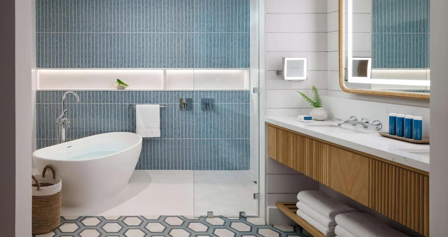 Freestanding tub, glass shower, and vanity in a bathroom at Sandals Montego Bay.