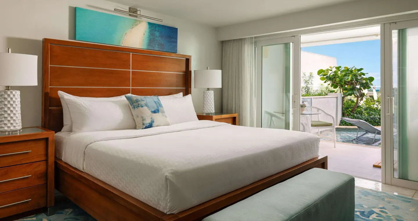 King bedroom with sliding doors to a garden patio at Sandals Montego Bay.