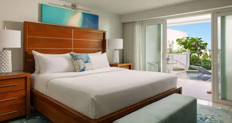 King bedroom with sliding doors to a garden patio at Sandals Montego Bay.