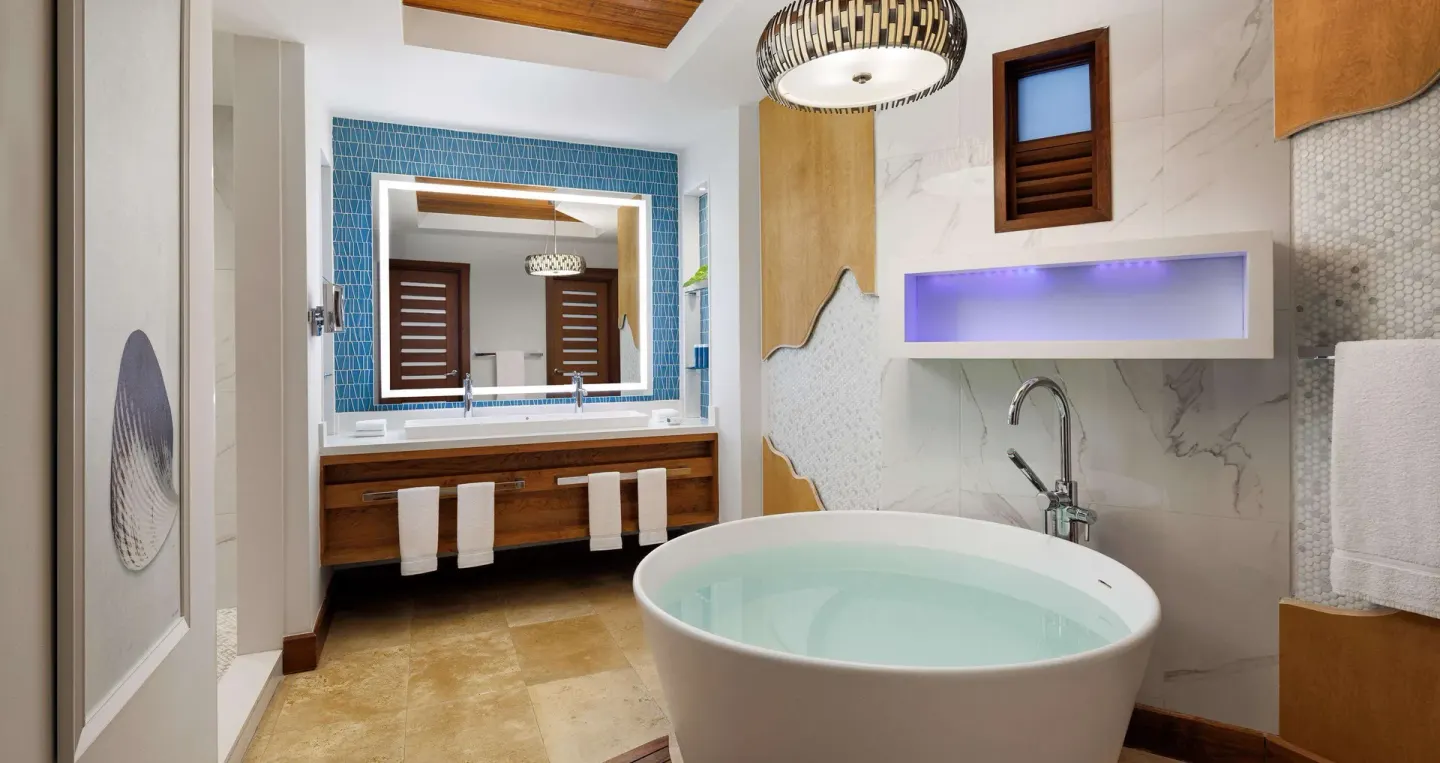 Bathroom with round soaking tub and blue tile vanity wall at Sandals Montego Bay.