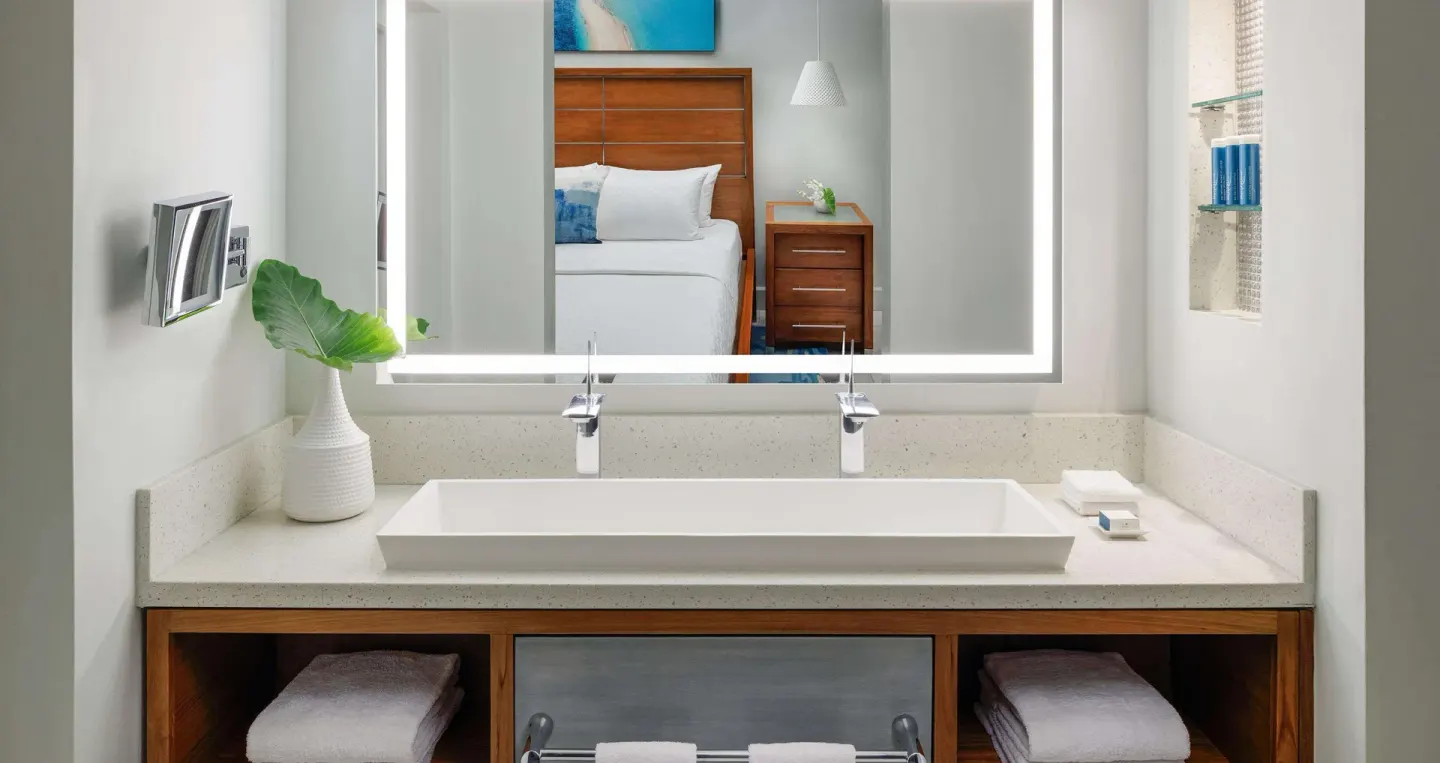 Club Penthouse bathroom vanity with bed reflected at Sandals Montego Bay.