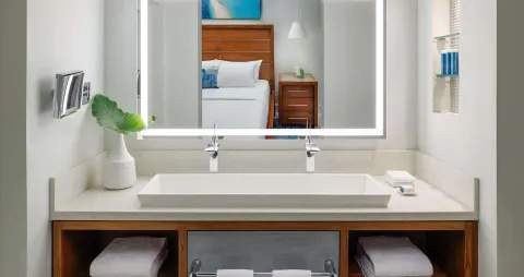 Club Penthouse bathroom vanity with bed reflected at Sandals Montego Bay.