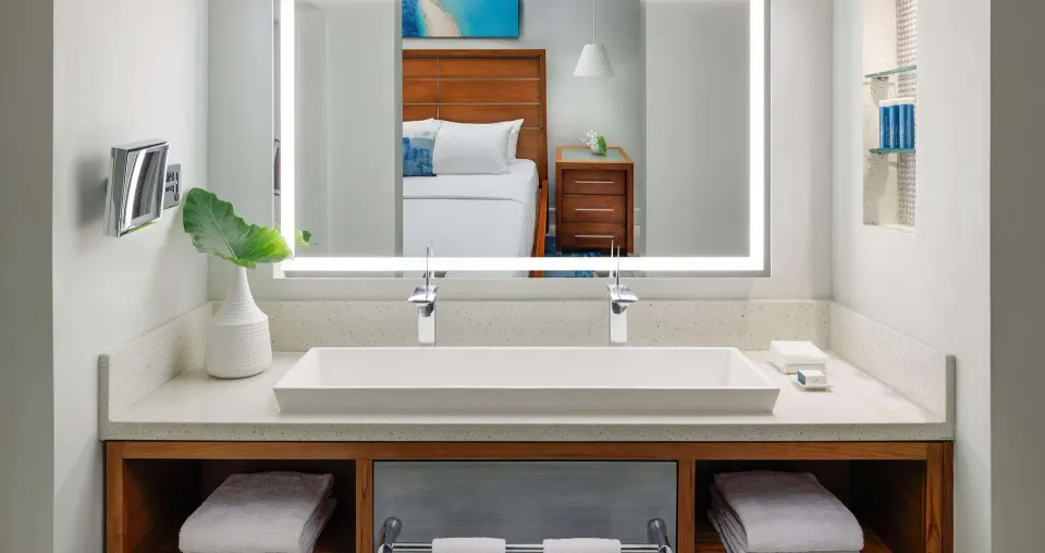Club Penthouse bathroom vanity with bed reflected at Sandals Montego Bay.