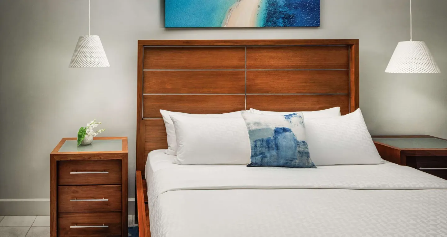 Close view of the king bed and wood headboard in a penthouse room at Sandals Montego Bay.