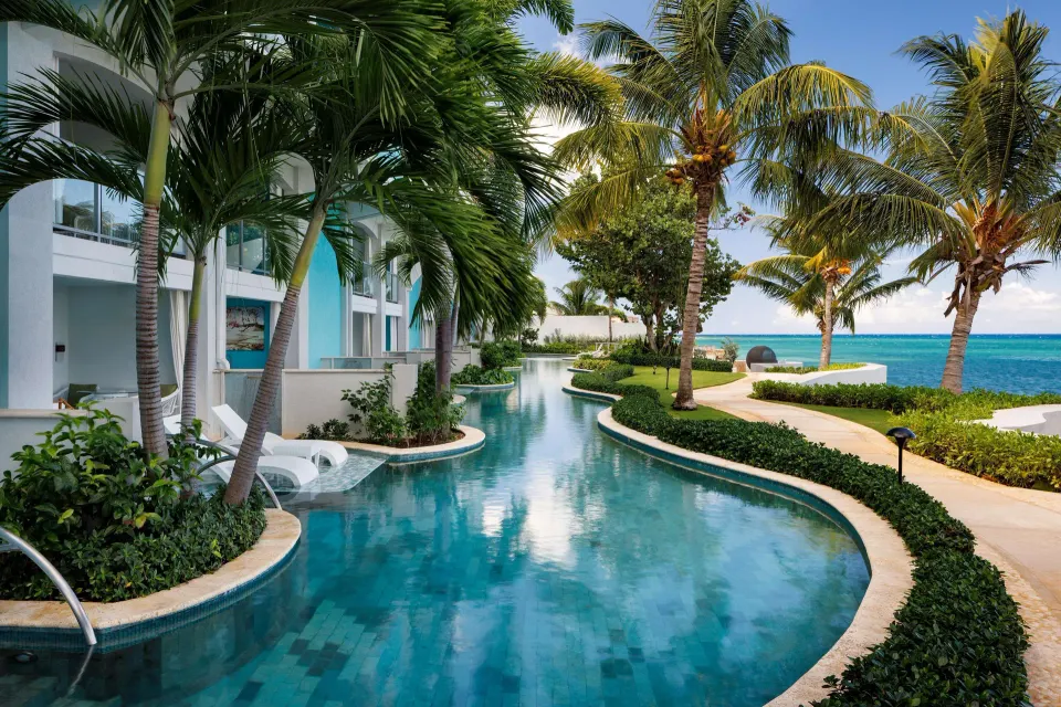 Palm-lined pool beside oceanfront guest rooms at Sandals Montego Bay.