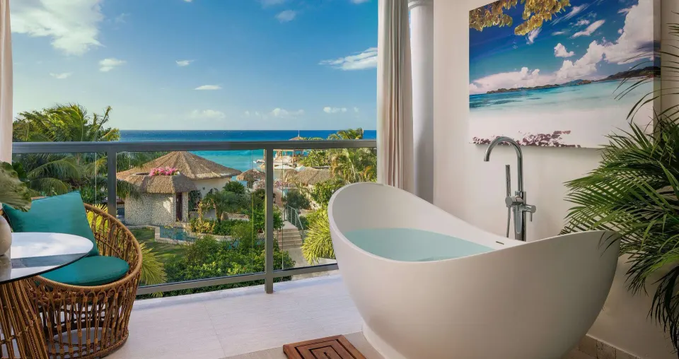 Balcony soaking tub with ocean view from a honeymoon room at Sandals Montego Bay.