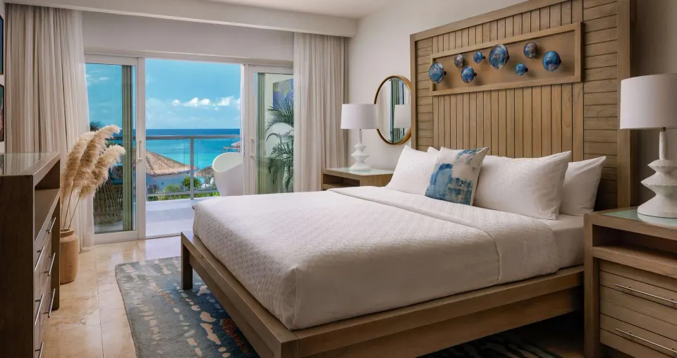 Honeymoon room king bed with balcony and ocean view at Sandals Montego Bay.