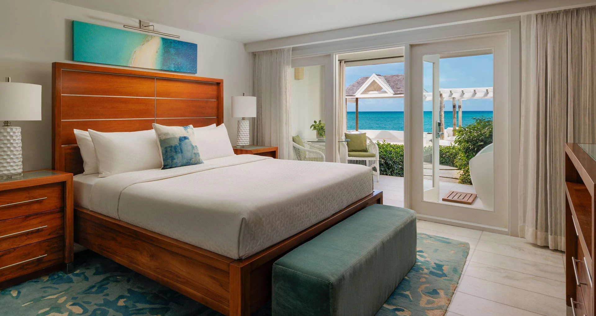 Oceanfront honeymoon room with king bed and walkout patio at Sandals Montego Bay.