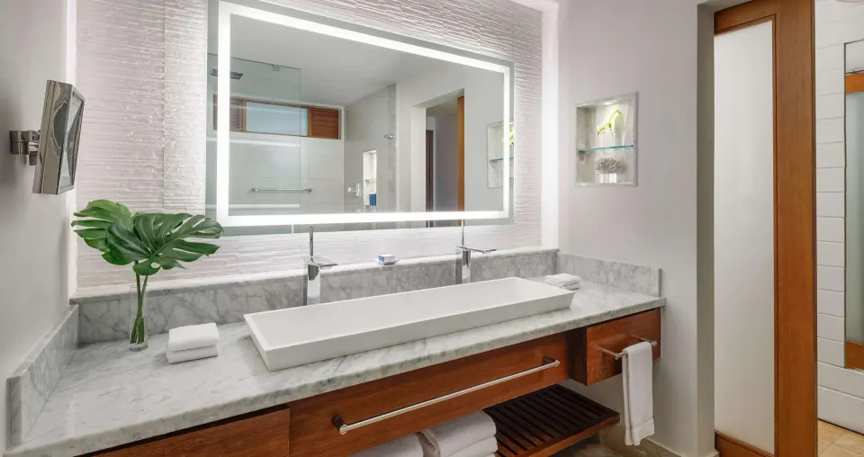 Marble vanity and illuminated mirror in a suite bathroom at Sandals Montego Bay.