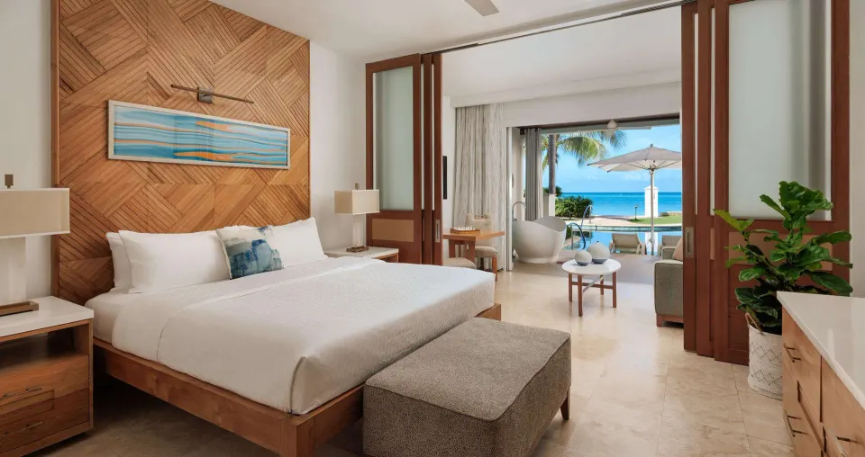 Ocean-view luxury suite with king bed and swim-up terrace at Sandals Montego Bay.