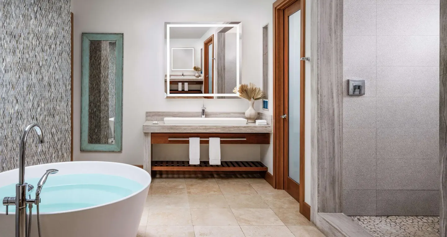 Villa bathroom with soaking tub, vanity, and walk-in shower at Sandals Montego Bay.