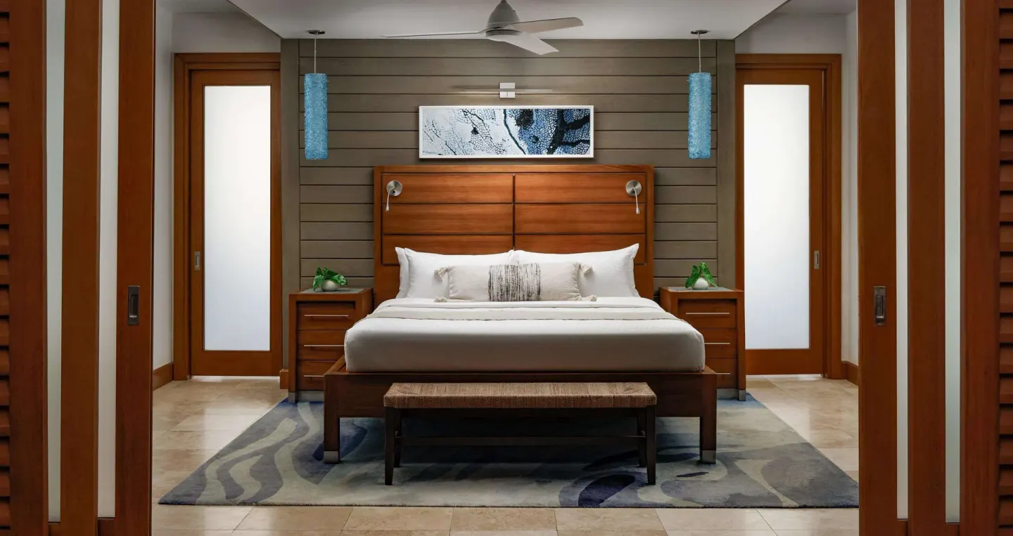 King bed with wood headboard in an ocean-view villa at Sandals Montego Bay.