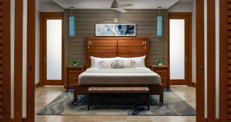 King bed with wood headboard in an ocean-view villa at Sandals Montego Bay.