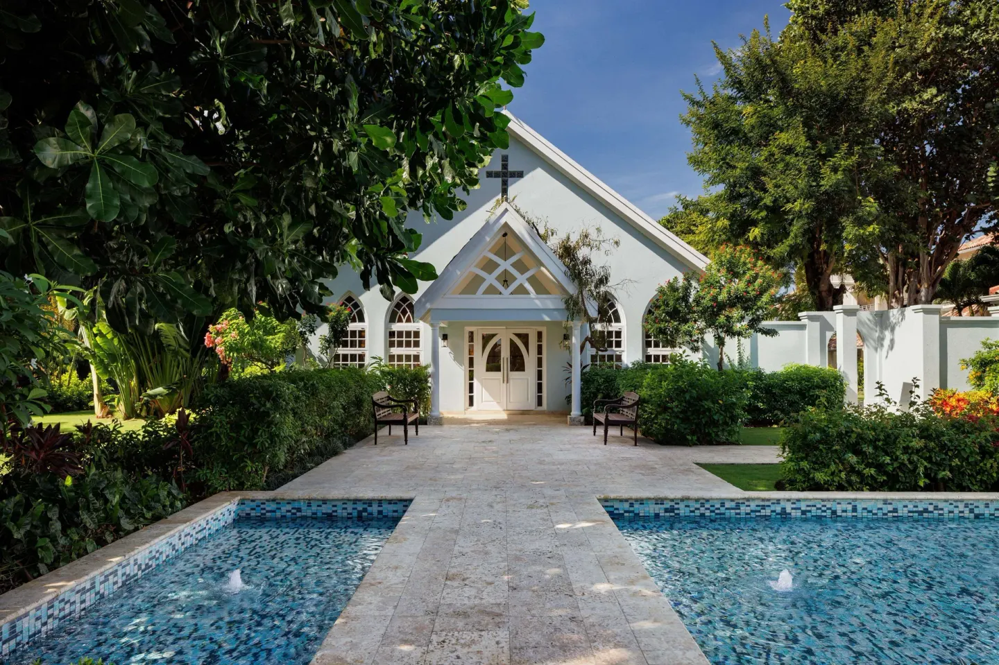White chapel entrance framed by gardens and reflecting pools at Sandals Montego Bay.