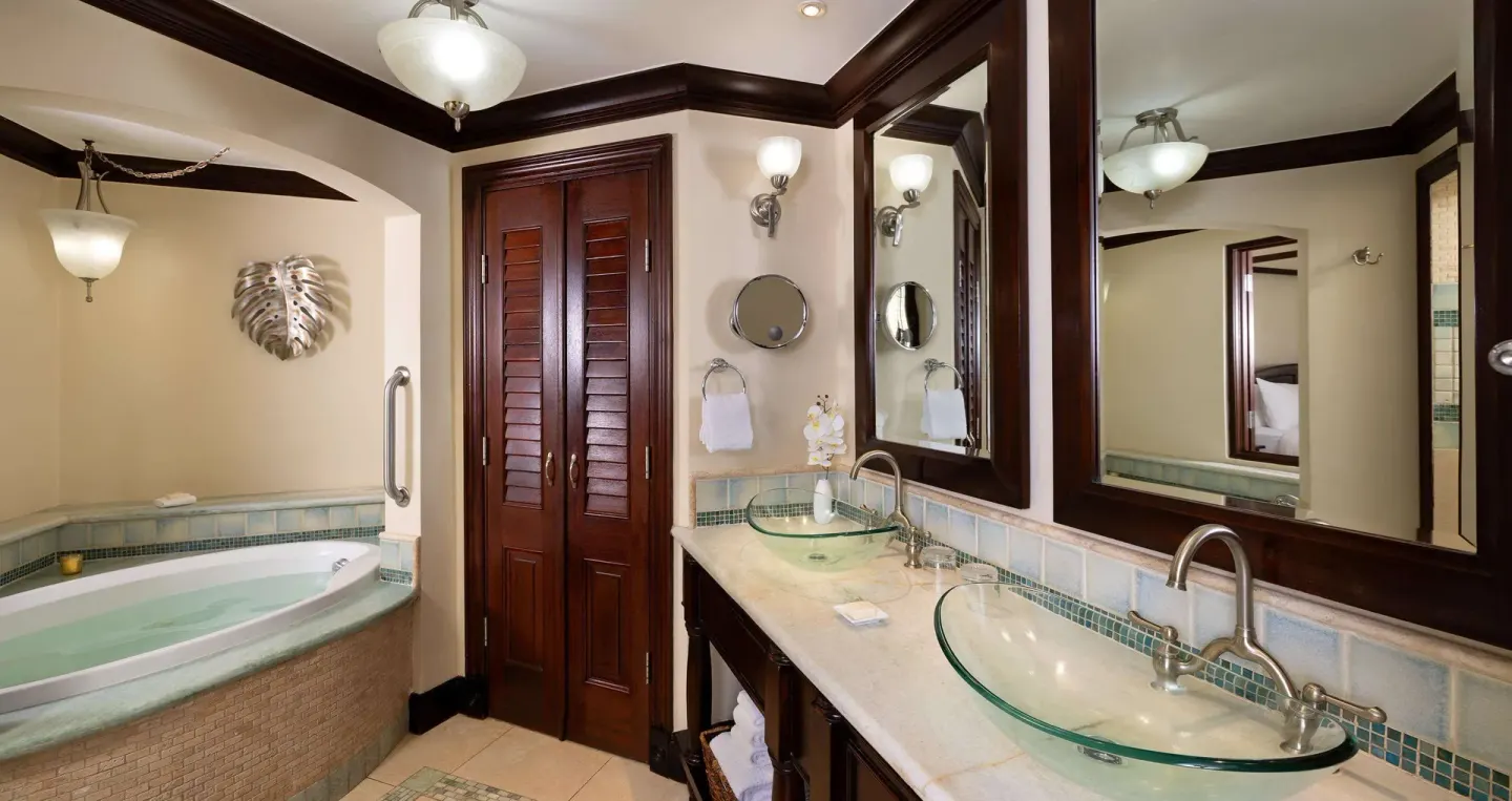 Bathroom with soaking tub and double glass sinks at Sandals Negril.