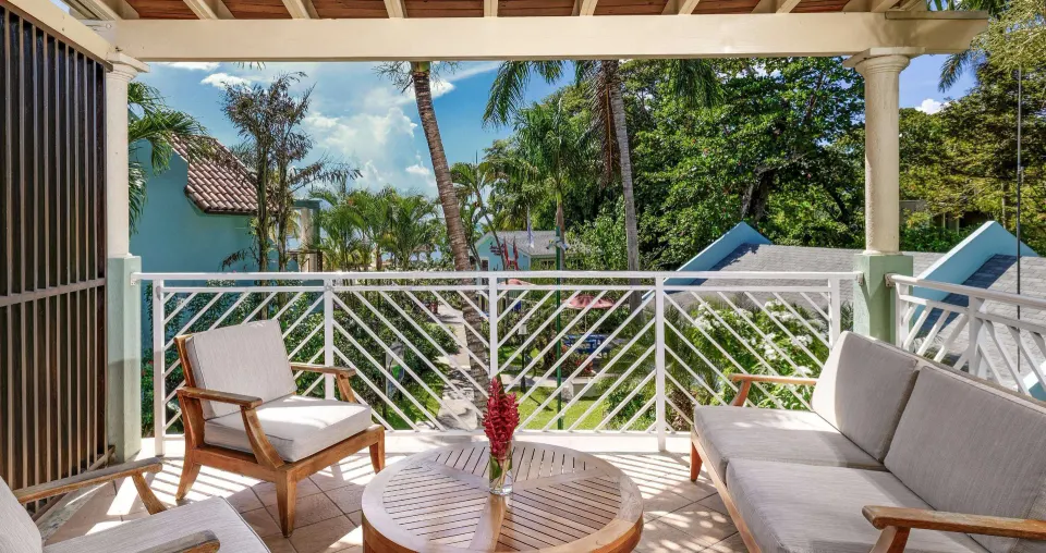Furnished balcony overlooking tropical gardens at Sandals Negril.