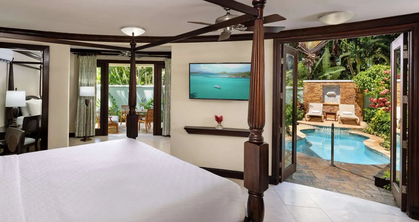 Guest suite with a four-poster king bed opening to a small private plunge pool at Sandals Negril.